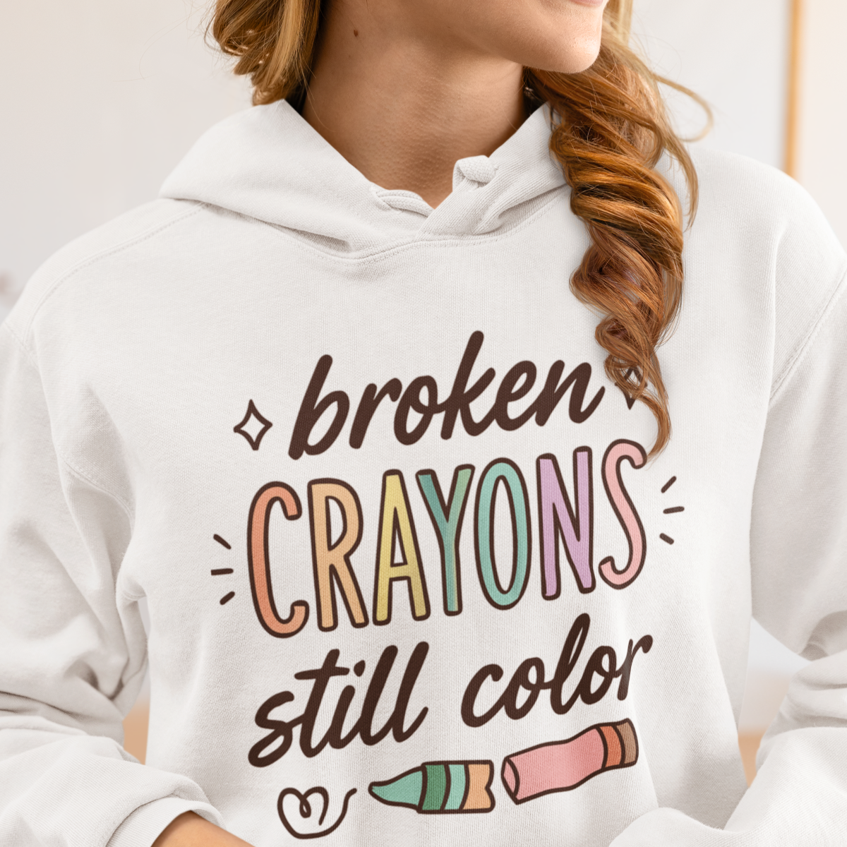 Weibliches Model trägt weißen Hoodie "Broken crayons still color" 
